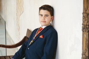 Sesión de fotos de comunión en jardín Niño de comunión posando al aire libre Fotografía de comunión