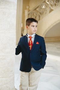 Sesión de fotos de comunión en jardín Niño de comunión posando al aire libre Fotografía de comunión