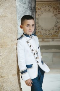 Sesión de fotos de comunión en jardín Niño de comunión posando al aire libre Fotografía de comunión