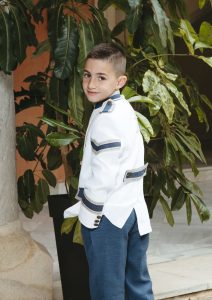 Sesión de fotos de comunión en jardín Niño de comunión posando al aire libre Fotografía de comunión