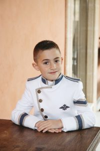 Sesión de fotos de comunión en jardín Niño de comunión posando al aire libre Fotografía de comunión