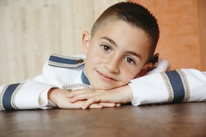 Sesión de fotos de comunión en jardín Niño de comunión posando al aire libre Fotografía de comunión