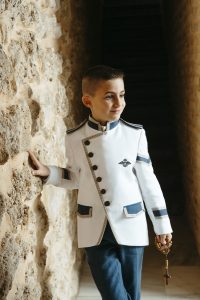 Sesión de fotos de comunión en jardín Niño de comunión posando al aire libre Fotografía de comunión