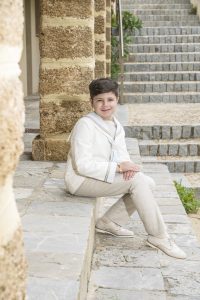 Sesión de fotos de comunión en jardín Niño de comunión posando al aire libre Fotografía de comunión