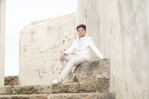 Sesión de fotos de comunión en jardín Niño de comunión posando al aire libre Fotografía de comunión