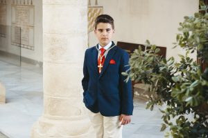 Sesión de fotos de comunión en jardín Niño de comunión posando al aire libre Fotografía de comunión