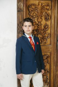 Sesión de fotos de comunión en jardín Niño de comunión posando al aire libre Fotografía de comunión